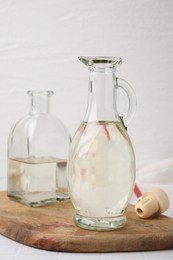 Photo of Vinegar in glass jug and bottle on table