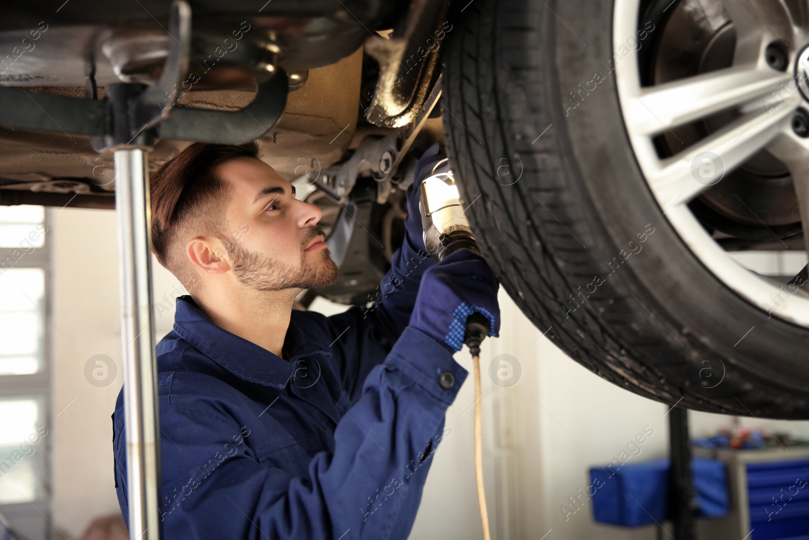 Photo of Technician checking modern car at automobile repair shop