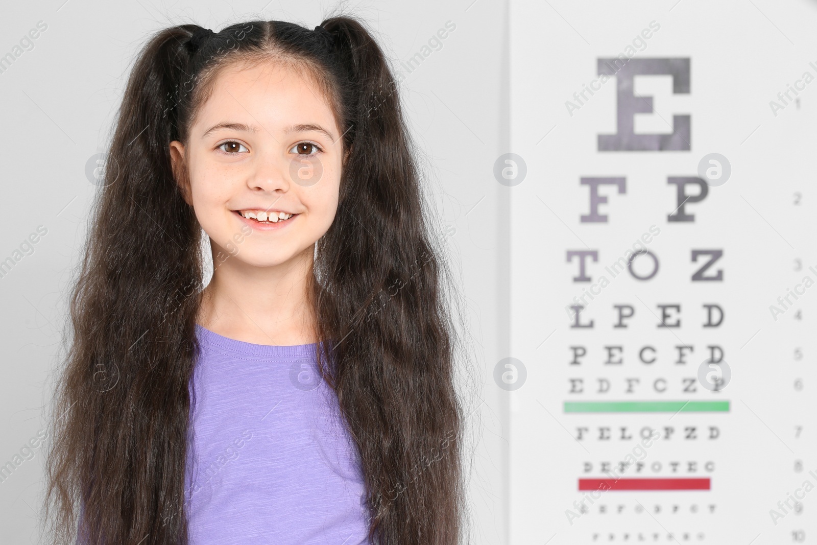 Photo of Portrait of cute little girl visiting children's doctor, space for text. Eye examination