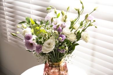 Photo of Bouquet of beautiful Eustoma flowers in room, closeup