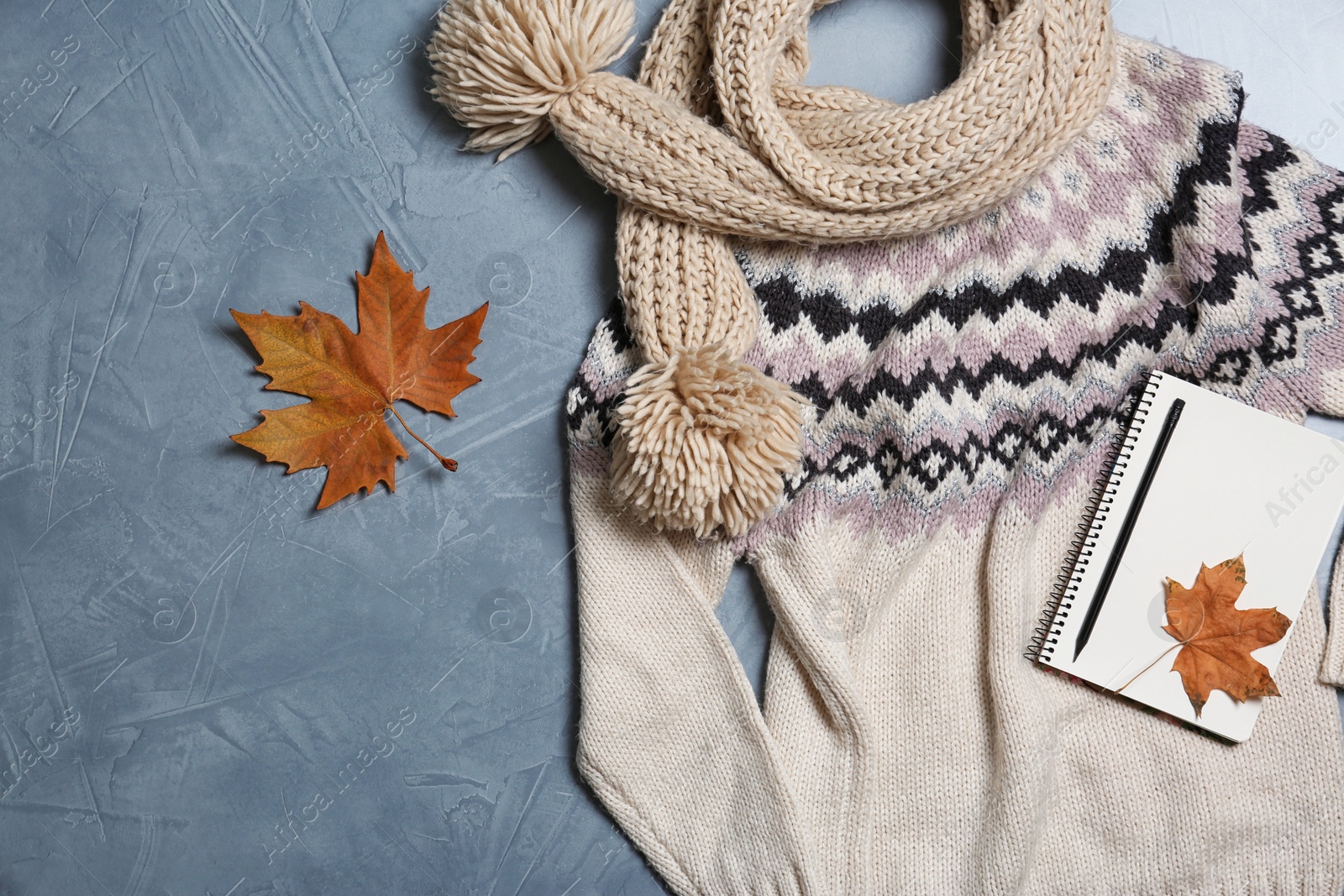 Photo of Flat lay composition with warm sweater and scarf on color background