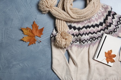 Photo of Flat lay composition with warm sweater and scarf on color background