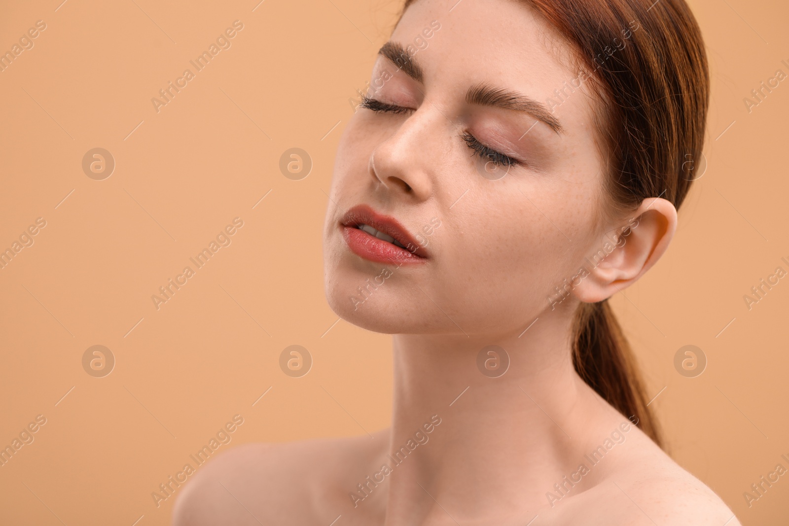 Photo of Portrait of beautiful woman with freckles on beige background. Space for text