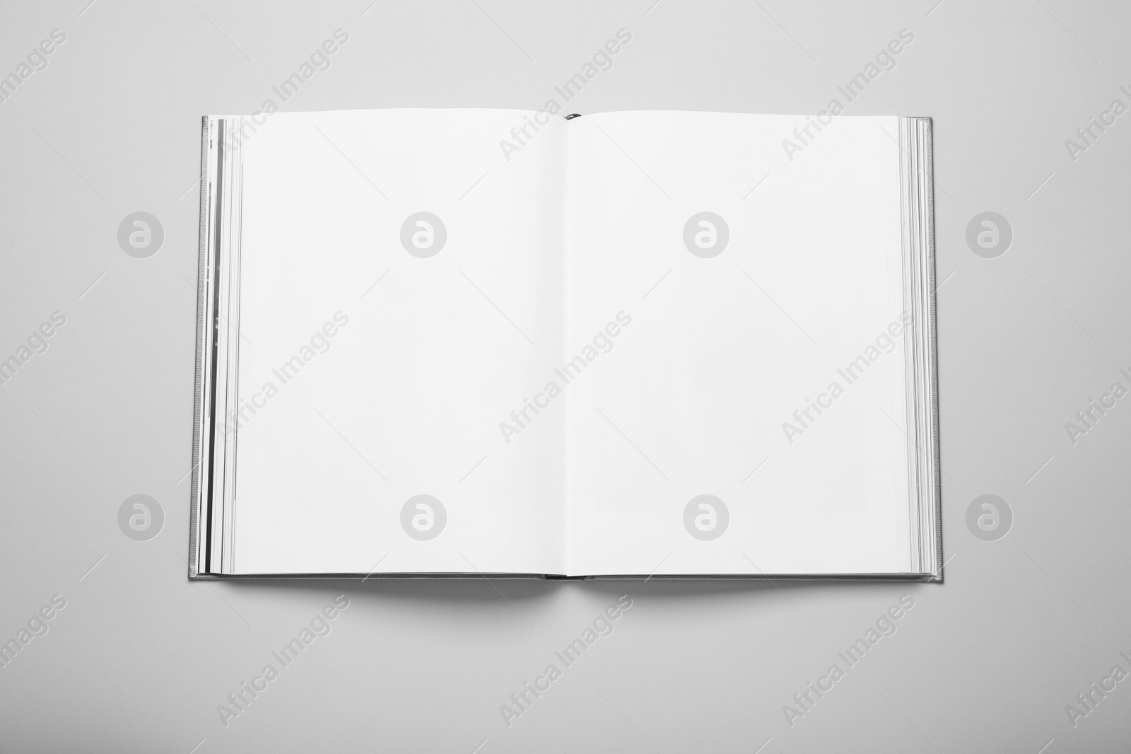 Photo of Open book with hard cover on white background, top view