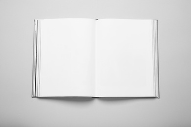 Photo of Open book with hard cover on white background, top view