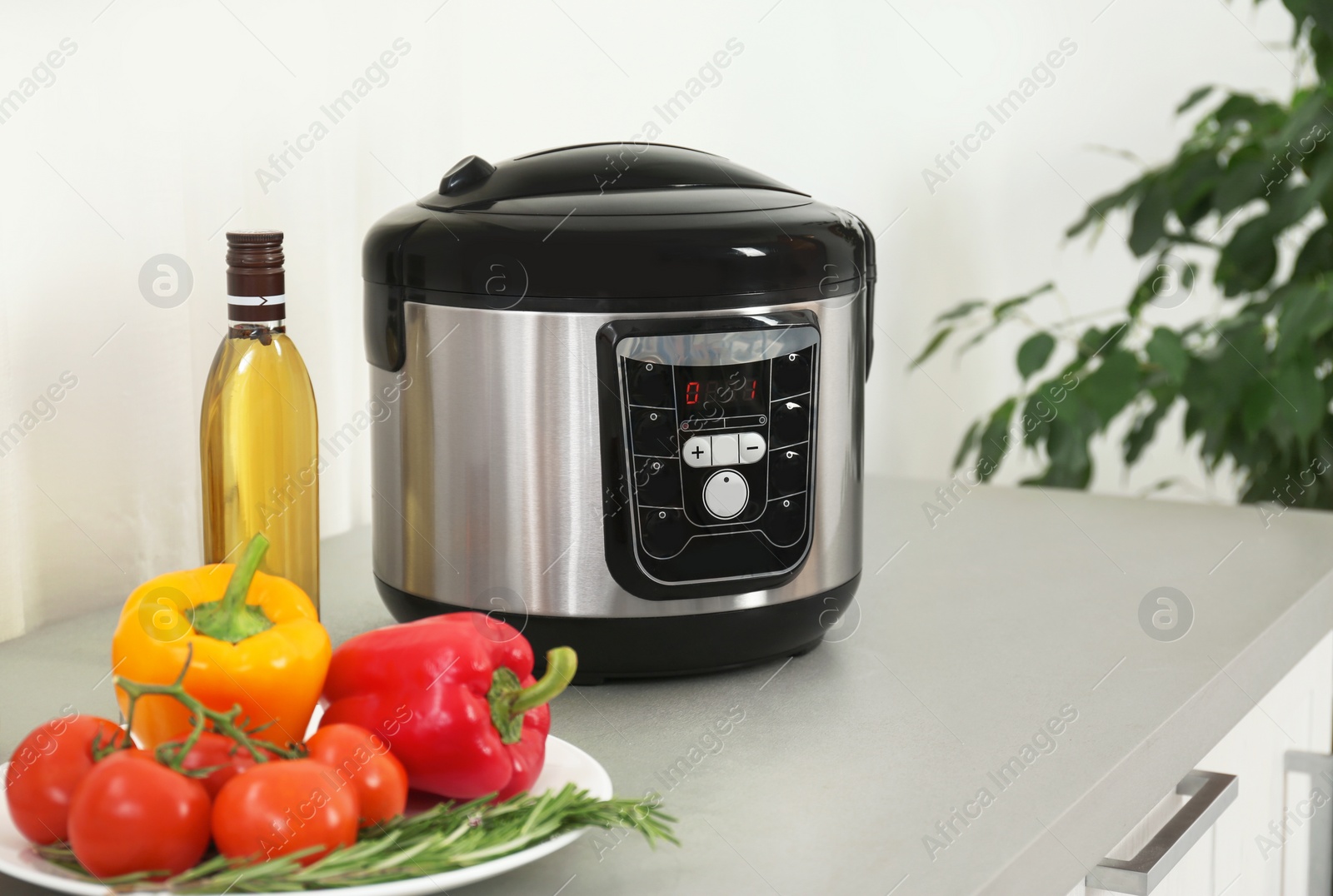 Photo of Modern multi cooker and products on kitchen table. Space for text