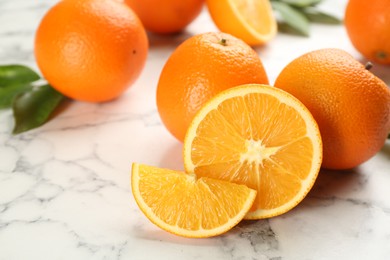 Photo of Delicious ripe oranges on white marble table, closeup