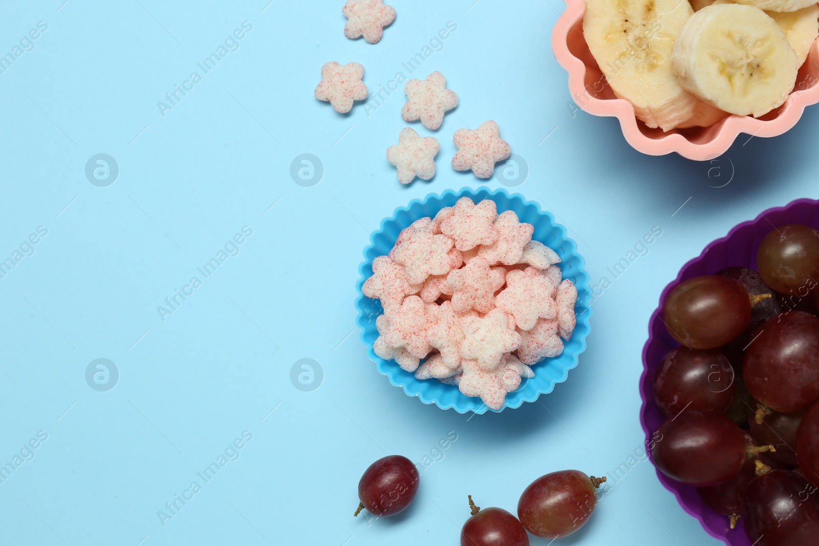 Photo of Different baby finger foods on light blue background, flat lay. Space for text