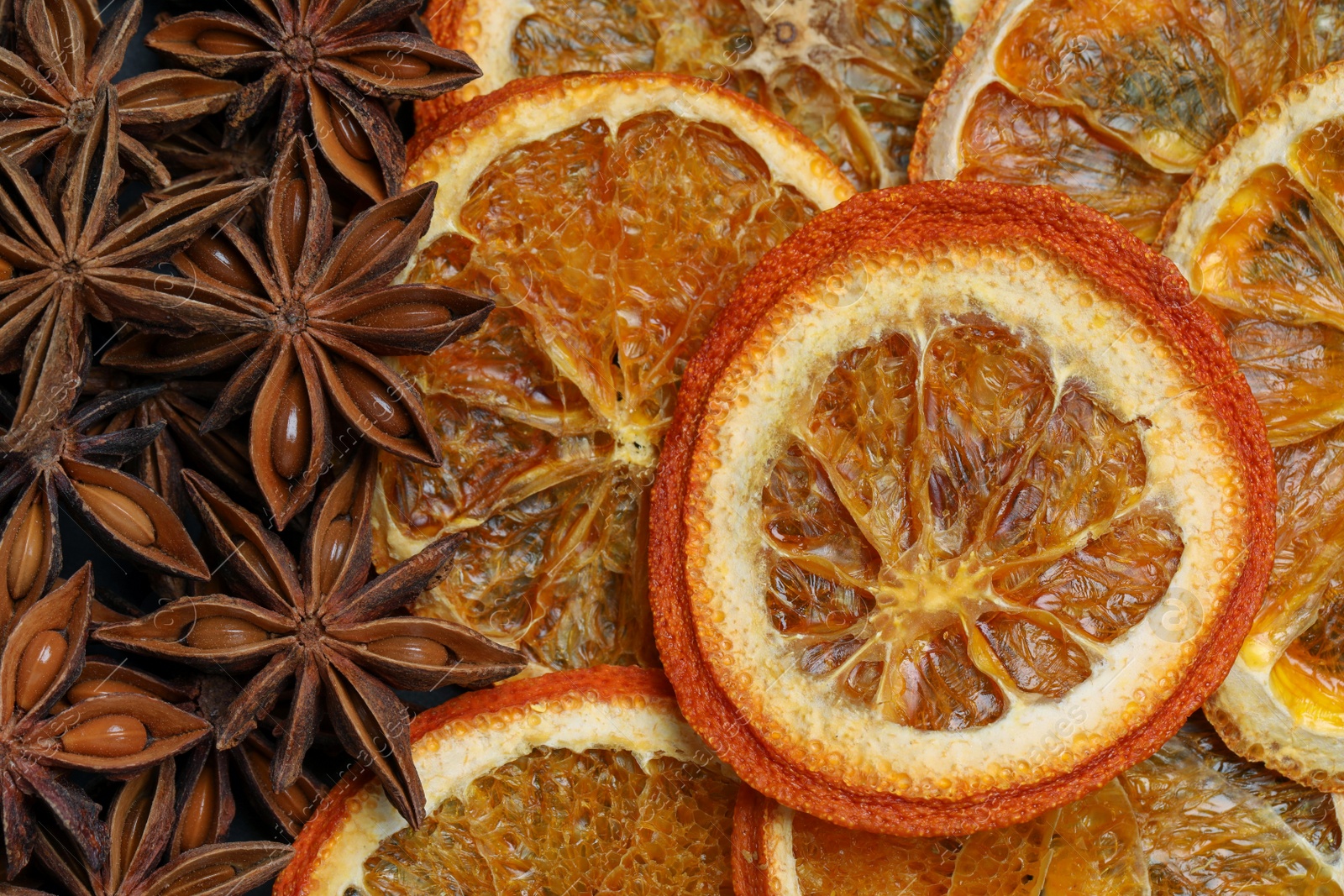 Photo of Dry orange slices and anise stars as background, top view