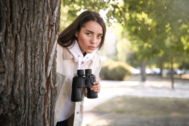 Photo of Jealous woman with binoculars spying on ex boyfriend in park