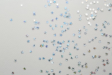 Confetti stars on grey background, flat lay Christmas celebration