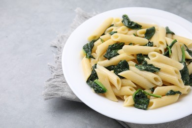 Photo of Tasty pasta with spinach and sauce on grey table. Space for text