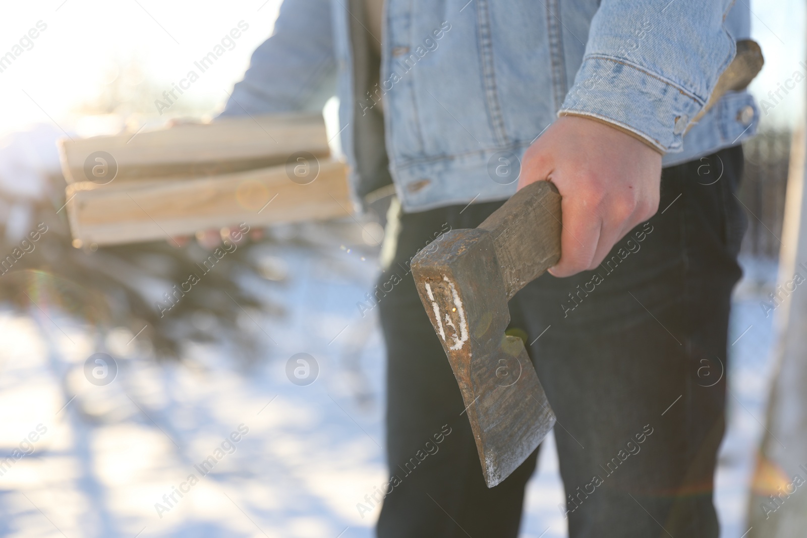 Photo of Man with axe and wood outdoors on sunny winter day, closeup