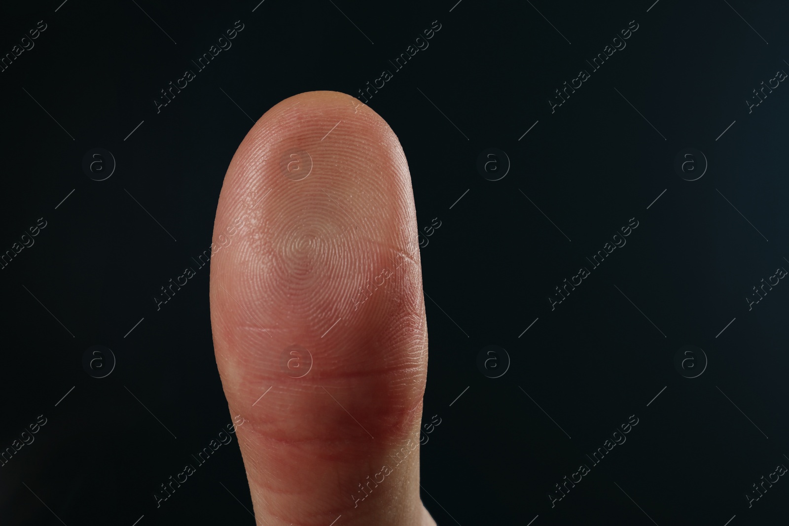 Photo of Man pressing control glass of biometric fingerprint scanner on dark background, closeup. Space for text