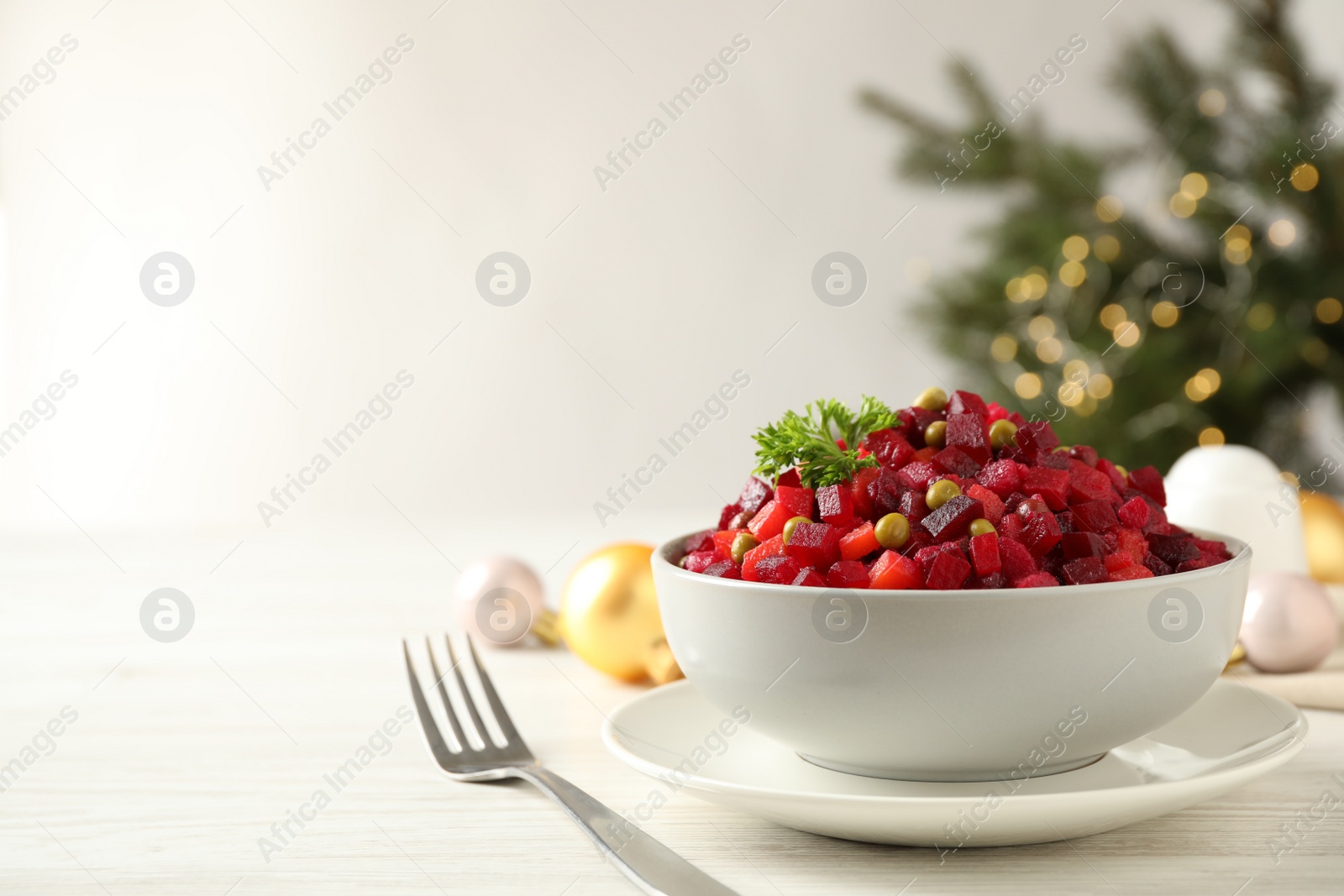 Photo of Traditional Russian salad vinaigrette served on white wooden table. Space for text