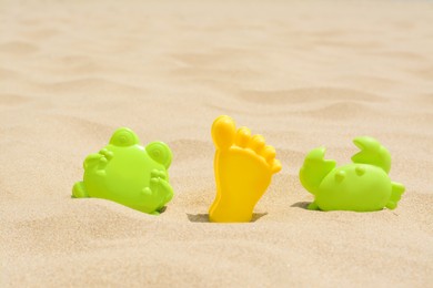 Photo of Colorful plastic molds on sand, space for text. Beach toys