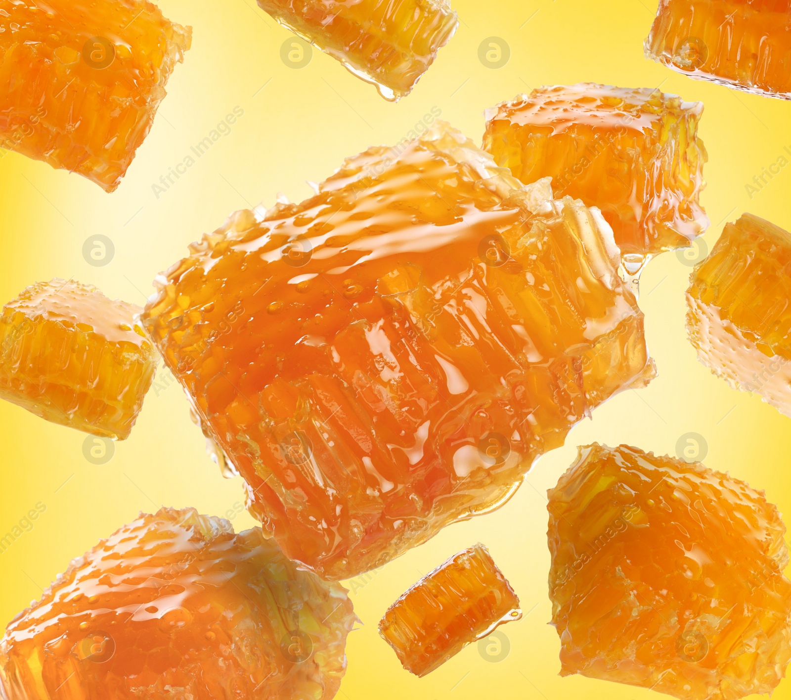 Image of Pieces of honeycomb falling on yellow background