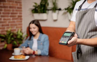 Photo of Waiter with payment terminal in cafe, closeup. Space for text