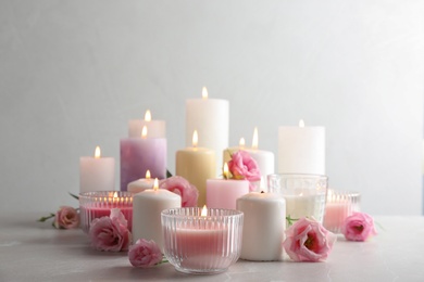 Composition with burning candles on table against light background