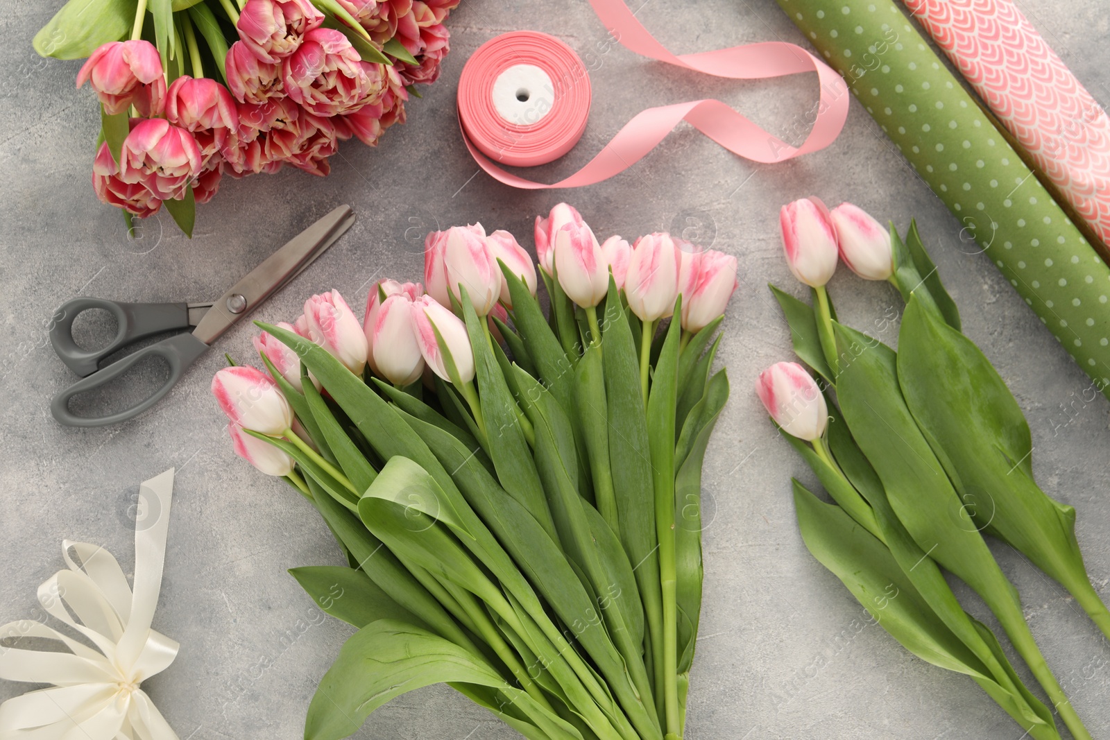 Photo of Beautiful pink tulips on grey table, flat lay