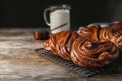 Photo of Tasty sweet buns with poppy seeds on wooden table. Space for text