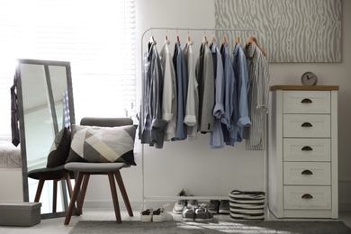 Photo of Dressing room interior with clothing rack and mirror