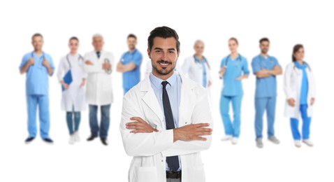 Image of Handsome young doctor and blurred view of medical staff on white background. Banner design