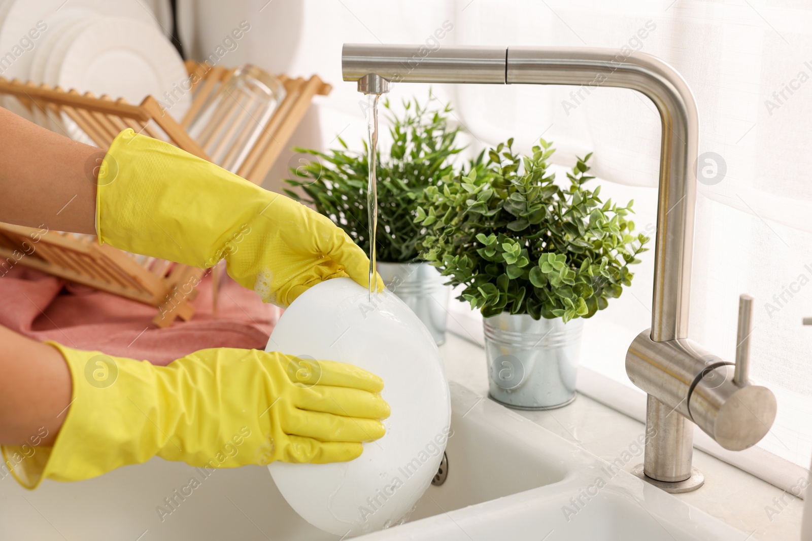 Photo of Woman washing bowl at sink in kitchen, closeup