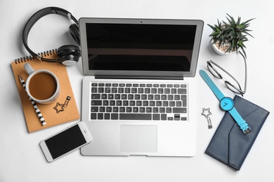 Blogger's workplace with laptop, smartphone and accessories on white background, top view