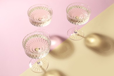 Photo of Glasses of expensive white wine on color background