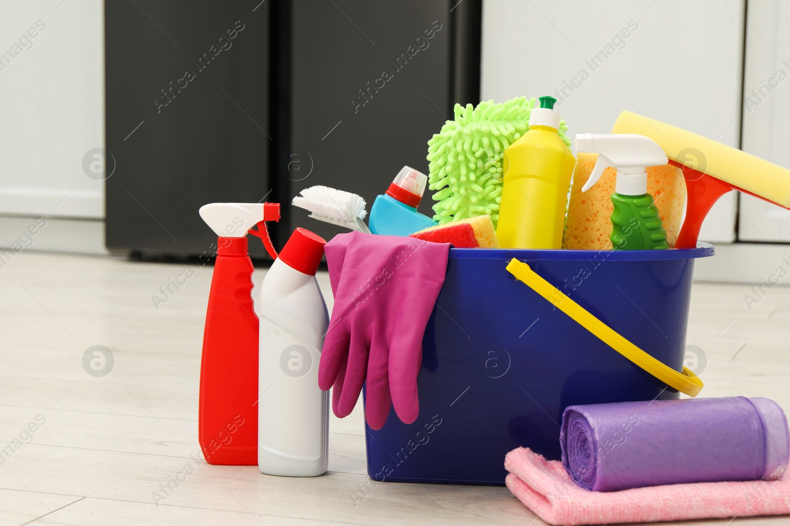 Photo of Different cleaning supplies in bucket on floor