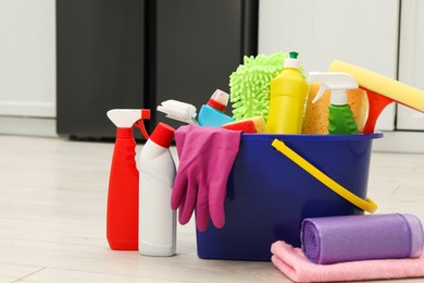 Photo of Different cleaning supplies in bucket on floor