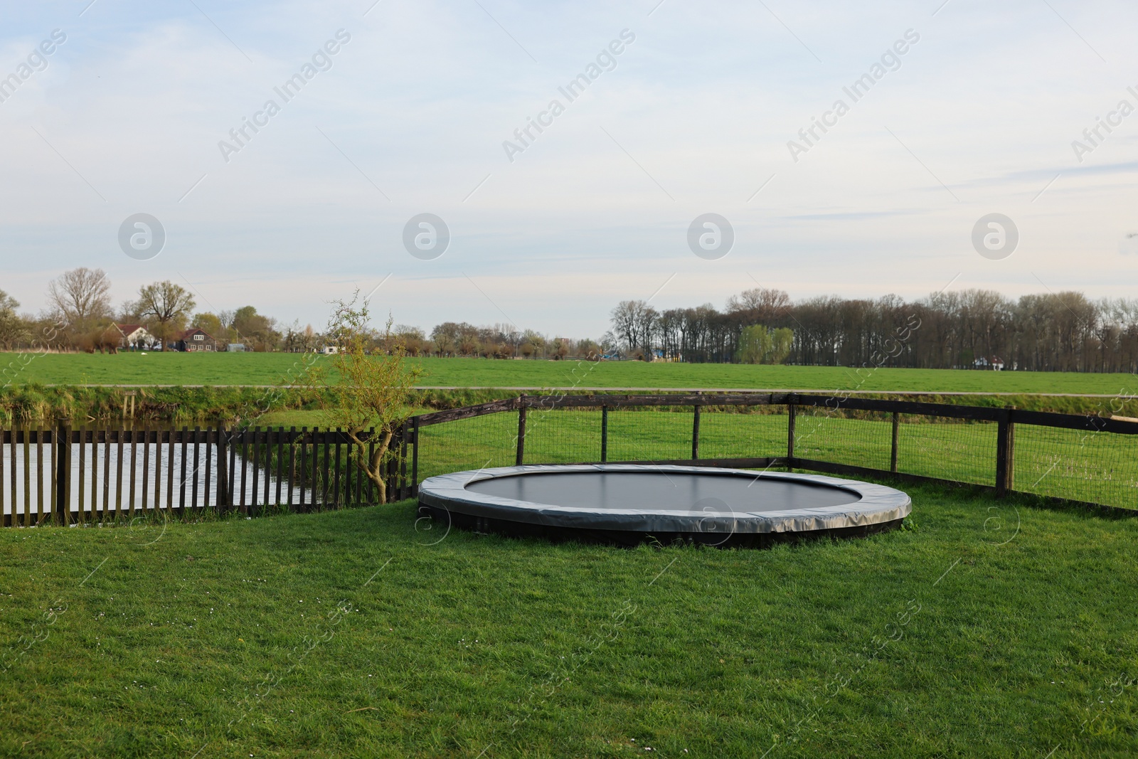 Photo of Beautiful view of green lawn with big trampoline