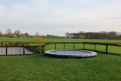 Photo of Beautiful view of green lawn with big trampoline