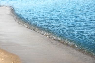 Photo of View of sea water and beach sand on sunny summer day