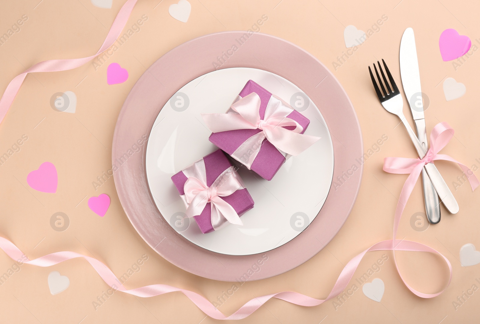 Photo of Beautiful table setting for Valentine's Day dinner on beige background, flat lay