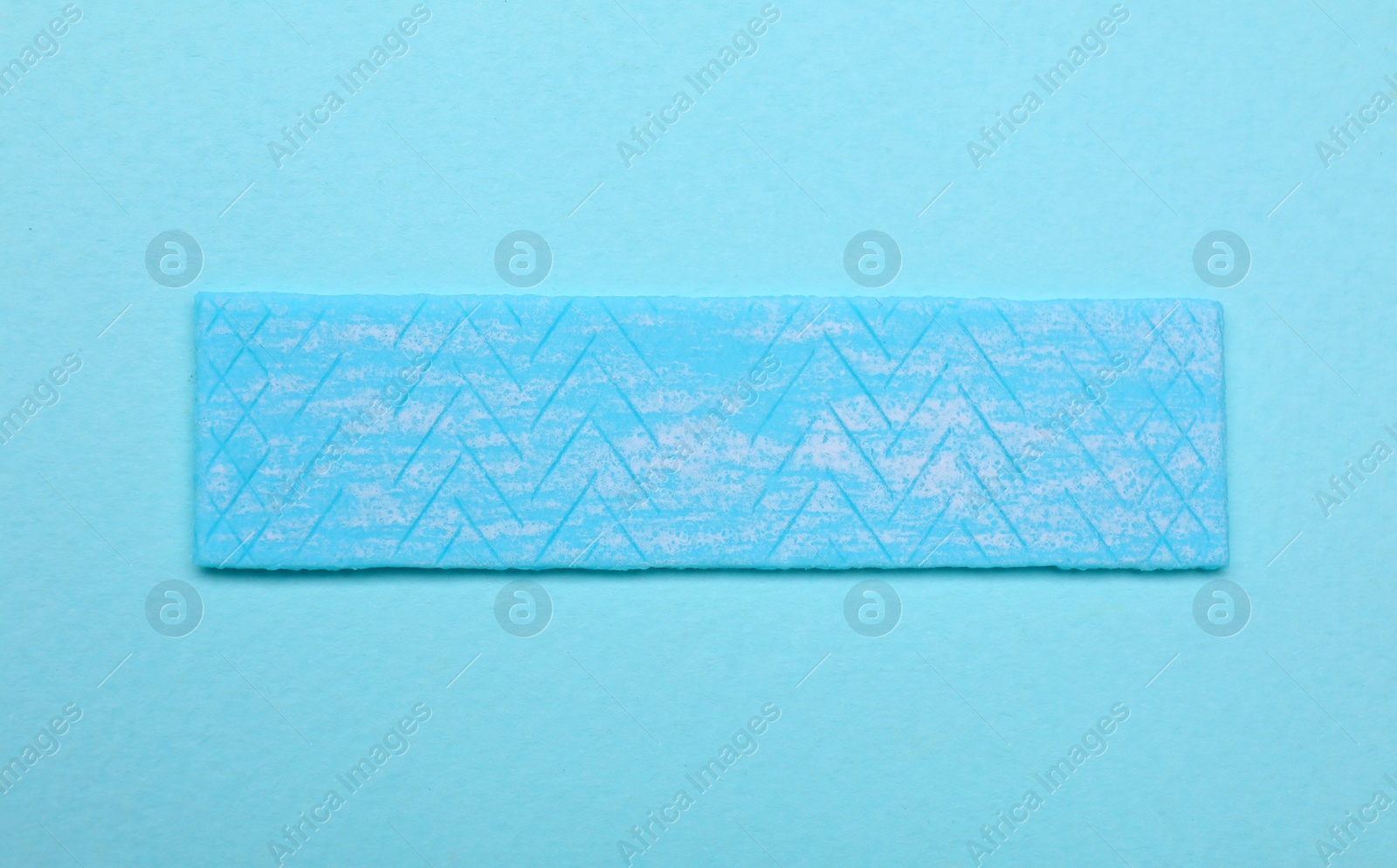 Photo of One stick of chewing gum on turquoise background, top view