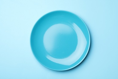 Stylish ceramic plate on color background, top view