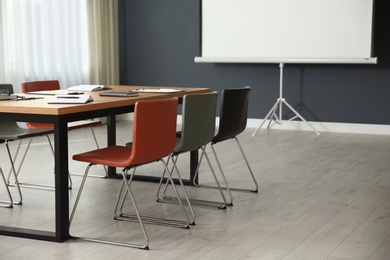 Photo of Modern meeting room interior with large table and projection screen