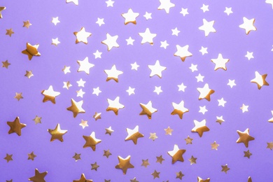 Photo of Confetti stars on violet background, flat lay. Christmas celebration