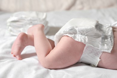 Little baby in diaper lying on bed, closeup