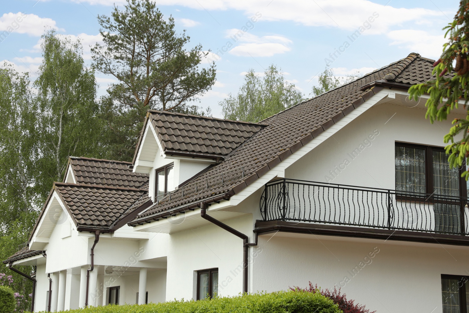 Photo of Modern building with brown roof outdoors on spring day