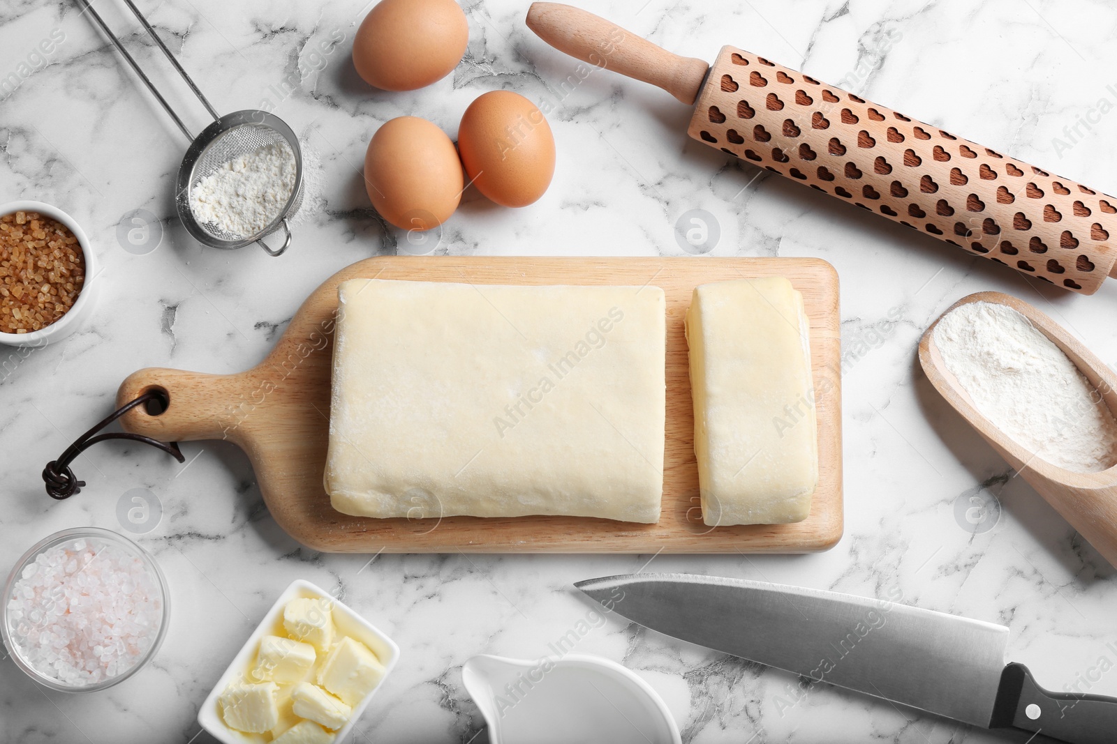 Photo of Flat lay composition of puff pastry dough and ingredients on white marble table