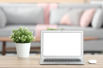 Laptop with blank screen on table indoors. Space for text