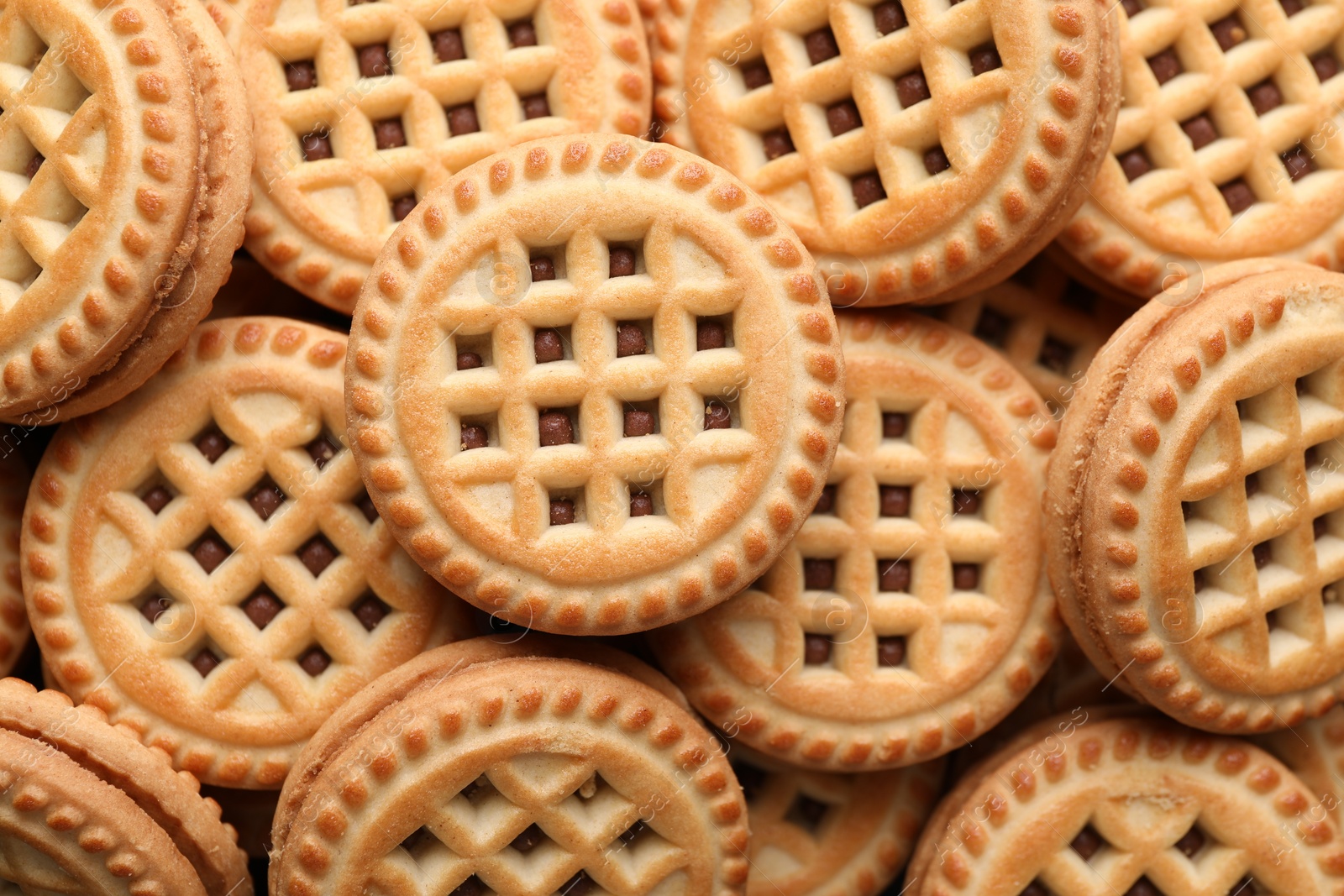 Photo of Tasty sandwich cookies with cream as background, top view