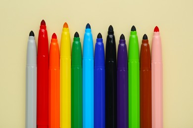 Many different colorful markers on beige background, flat lay