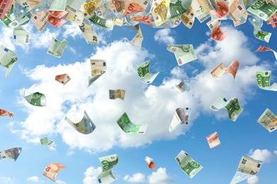 Image of Falling Euro banknotes and blue sky on background. Money rain