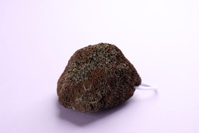 Photo of Pumice stone on violet background. Pedicure tool