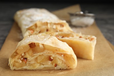 Delicious apple strudel with almonds on parchment, closeup