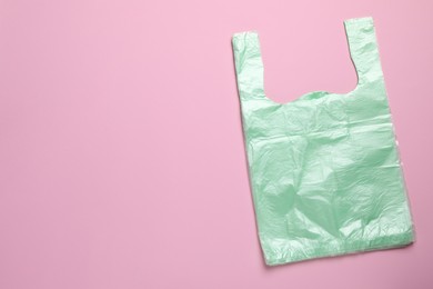 Pack of plastic bags on pink background, top view. Space for text